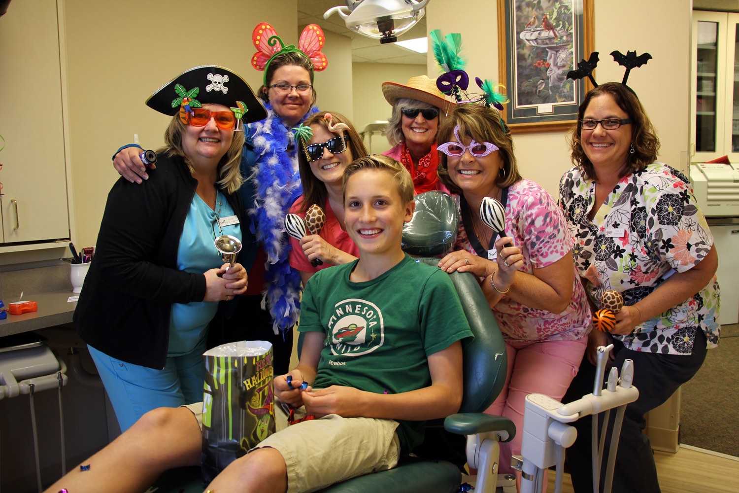 A boy in an exam chair poses with Bemidji Orthodontics after band removal.